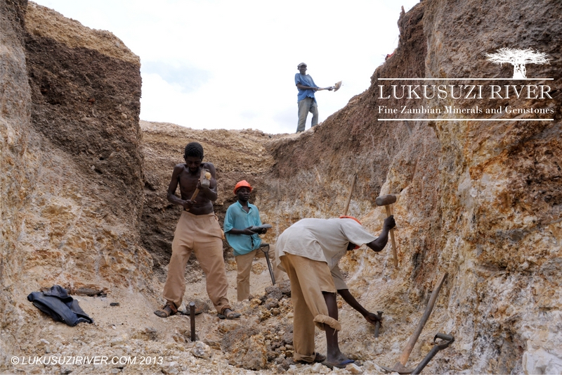 Mumba: The two workers in the front are the chisel men, who break the rock. The two men in the back are the dumpers, who shovel the loose material out of the pit and onto the dumps.